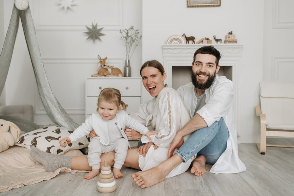 happy mum dad baby sitting on the floor
